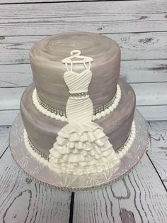 a three tiered wedding cake with a dress on top