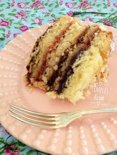 a piece of cake sitting on top of a pink plate with a fork next to it