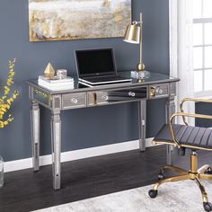 a laptop computer sitting on top of a desk next to a lamp and chair in a room