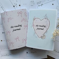 two greeting cards with writing on them sitting next to each other and flowers in front of them