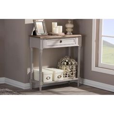 a white console table with drawers and candles on the top, in front of a window