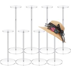 a hat is sitting on top of several glass shelves with metal poles in front of it