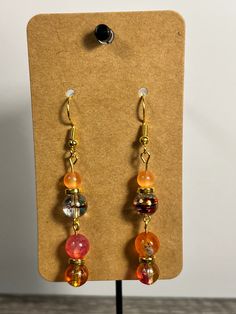 Handmade Earrings - Colors Series Each piece is meticulously handcrafted using craft wire, hypoallergenic earring hooks, and premium beads including crystal, glass, wood, ceramic, acrylic, resin, stone, and silicone beads. Care Instructions: Avoid moisture. Remove prior to bathing, showering, swimming, or exercising. Avoid allowing the item to fold when storing.  Shipping Information: Your items will be shipped within 1-2 business days once payment is received. Shipping within the US is via first class mail or you may choose to upgrade to Priority Mail for a small fee. Each item is carefully wrapped and packaged for safety during transit. Returns & Exchanges: As this is a wearable item, I do not accept returns or exchanges on this item. All sales are final. If there is a problem once your Handmade Amber Round Bead Earrings, Handmade Amber Beaded Round Earrings, Orange Czech Glass Dangle Earrings, Handmade Amber Earrings With Round Beads, Handmade Adjustable Amber Earrings, Glass Dangle Jewelry With Dangling Beads, Glass Jewelry With Dangling Beads, Orange Czech Glass Jewelry With Ear Wire, Resin Drop Earrings With Ear Wire