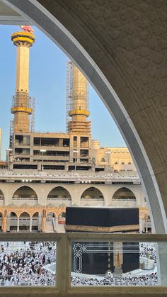 the kabab is shown through an arch in front of a large building with many people around it