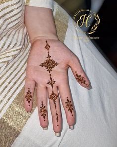 a woman's hand with henna tattoos on it