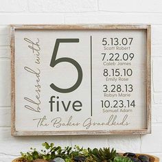 a wooden sign with numbers and plants in it on a shelf next to a potted plant