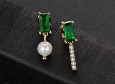 Asymmetrical emerald green stud earrings, beautiful natural pearl and sparkling cz diamond dangle. Stunning emerald and gold minimalist earrings, dainty and delicate vibes, easily transitions from day to night. Gorgeous addition to your style, looks elegant and luxurious, also a perfect gift idea for your love ones and yourself! Can be purchased SEPARATELY for 1 PIECE or 1 PAIR, easy to mix and match at your own preference! 💎 Features: ♥ Material: 14K Gold plated brass, 925 sterling silver ♥ Main stone: Natural pearl, every pearl is in unique shape ♥ Side Stone: Emerald green cubic zircon, Cz diamond ♥ Screw back Closure 💎 Details: ♥ Approximate Measurements: - Length: 2.2 cm - Width: 0.6 cm ♥ Lightweight, easy to wear ♥ Nickel/Lead Free, Hypoallergenic, good for sensitive skins 🎁 Packi Gold Minimalist Earrings, Green Stud Earrings, Natural Pearl Earrings, Emerald Green Earrings, Minimalist Earrings Gold, Beautiful Gift Wrapping, For Your Love, Earrings Dainty, Style Looks