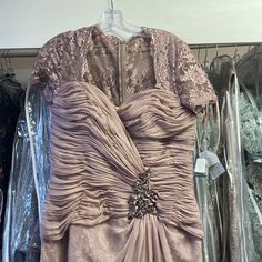 a dress that is sitting on a hanger in front of some other dresses and clothes