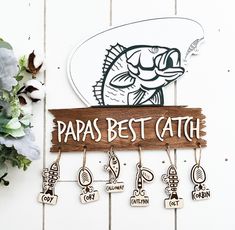 a sign that says papa's best catch hanging on a wall next to flowers