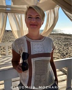 a woman standing on top of a beach next to the ocean