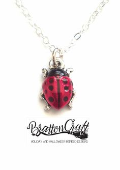 Hand Painted Red Ladybug Necklace.   The charm is made in the USA using lead-free Britannia pewter with a nickel compliant fine silver double plating. The charm is approximately 1/2 inches long and 3/8 inches wide. Kimberly hand painted the ladybugs using a nontoxic epoxy resin made with organic compounds. Cute Handmade Red Charm Necklace, Cute Handmade Red Charm Necklaces, Cute Red Handmade Charm Necklace, Nickel-free Themed Red Jewelry, Nickel-free Red Themed Jewelry, Themed Red Nickel-free Jewelry, Red Themed Necklace For Gift, Themed Red Necklace For Gifts, Themed Red Necklace For Gift