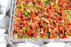 a metal pan filled with lots of food on top of a checkered table cloth