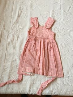 Vintage Kids pink patterned summer dress. Straps attach with buttons. No size on garment but would likely fit ages 6-8. Has small stains on fabric, pictured. Pink Summer Dress With Buttons, Cute Lined Cotton Sundress, Casual Pink Pinafore Dress For Spring, Pink Cotton Sundress For Picnic, Pink Cotton Sundress For Garden Party, Cute Sleeveless Dress With Button Closure, Vintage Pink Beach Dress, Vintage Sleeveless Pinafore Dress For Summer, Summer Gingham Dress With Button Closure