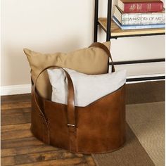 a brown bag sitting on top of a wooden floor next to a stack of books