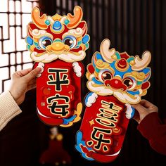 two people holding up red packets with chinese writing on them and an image of a dragon