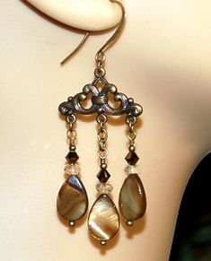 Semi precious Cognac Quartz, Swarovski Crystal, iridescent creamy brown shell drops and solid brass beads are featured in these chandelier earrings.  All metal is solid brass. Each earring weighs 4.9 grams as compared to a US dime weighing in at 2.268 grams. These earrings come with an earring reinforcement for support. Size and length can be determined in the photo above as compared to a US dime and a ruller. If you are interested in these earrings and would like more photos or have any questio Bone Beads, Pierced Earrings, Earrings Photo, Sterling Silver Bead, Chandelier Earrings, Earings Piercings, Silver Beads, Swarovski Crystal, Beautiful Earrings