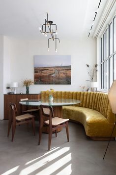 a living room filled with furniture and a large window covered in lots of windows next to a table