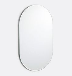 an oval mirror on the wall with no one around it, in front of a white background