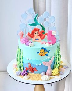 a birthday cake decorated with an ariel the mermaid theme