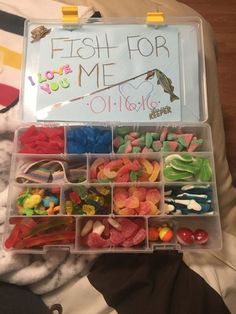 a plastic box filled with lots of different types of candies and fish for me