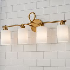 a bathroom light with five lights on it and white brick wall in the back ground