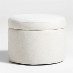 a white round ottoman sitting on top of a floor