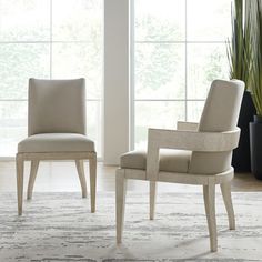 two white chairs in front of large windows