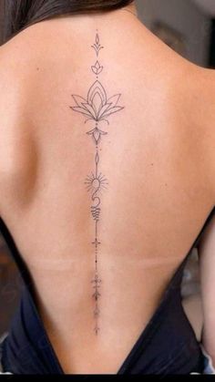 the back of a woman's neck with a flower tattoo on her lower back