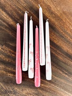 three pink candles sitting on top of a wooden table