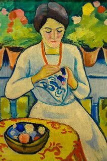 a painting of a woman sitting at a table with eggs in a bowl on it