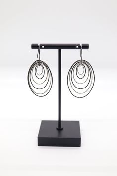 The Silver and Black Multi-Circles Italian Dangle Earrings feature a dynamic arrangement of silver and black circles, exuding contemporary flair and contrast. Crafted in sterling silver, these earrings offer a modern and stylish accessory that effortlessly complements a variety of outfits. Modern Black Sterling Silver Earrings, Modern Black Hoop Earrings, Modern Black Round Hoop Earrings, Black Minimalist Sterling Silver Hoop Earrings, Modern Oval Sterling Silver Earrings, Modern Silver Oval Earrings, Modern Black Oxidized Jewelry, Modern Black Jewelry With Oxidized Finish, Modern Silver Linear Pierced Earrings