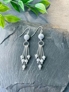 Elevate your style with these stunning white Howlite fringe earrings! The boho dangle design features natural Howlite gemstones gracefully suspended from silver hoops, exuding a unique and chic vibe. Ideal for both casual outings and special events. EARRING FEATURES Total Length: Approximately 2.5 inches Gemstone: Natural White Howlite Gemstones Metal: Silver  ♥ All orders come beautifully hand-packaged with care, making it the perfect gift for yourself or someone special. ♥ Each piece is handma Metal Fringe Earrings, White Crystal Dangle Earrings, Adjustable White Dangle Plug Earrings, White Sterling Silver Dangle Plug Earrings, Adjustable White Crystal Earrings, White Round Earrings With Dangling Beads, White Sterling Silver Earrings With Dangling Beads, White Round Chandelier Earrings Pierced, Hypoallergenic White Dangle Earrings