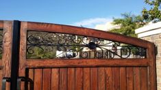 a wooden gate with wrought iron work on it