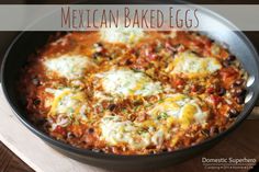 mexican baked eggs in a skillet on a wooden table with text overlay that reads, mexican baked eggs