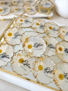 the table is decorated with white and yellow flowers on glass coasters that read, effinn & co