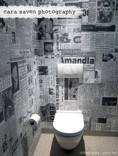 a toilet in a bathroom with newspaper wallpaper