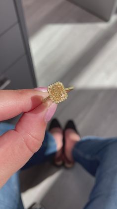 a person holding a tiny gold ring in their left hand and sitting on the floor