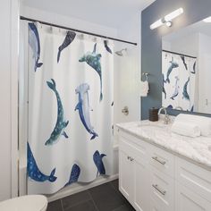 a bathroom with blue and white shower curtain in the shape of dolphins on it's side