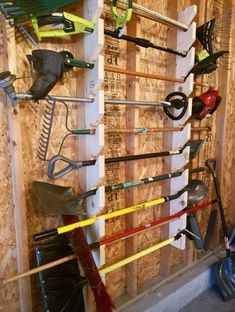 there are many different types of gardening tools hanging on the wall in this garage area