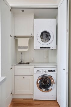 an appliance for washing clothes in a laundry room with white cabinets and appliances