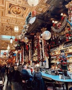 the interior of a bar with many decorations and lights hanging from the ceiling, along with people sitting at tables