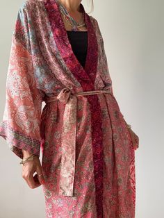 "This is one of a kind patchwork, upcycled silky robe Made free size with wrap tie closing and wide kimono sleeves  Easy and fun to wear around the house or outside as a urban boho style,  flowy kardigan with jeans and tshirt  It is very comfy and feels soft and light  the material is colourful and flowy  made into this unique stylish over all More boho style ideas at  https://www.etsy.com/shop/AltheaStores MEAESURE free size length 55\" MATERIAL *polyester * no lining CARE INSTRUCTIONS  * Wash Kaftan Dress Boho, Bohemian Robes, Urban Boho, Patchwork Kimono, Silky Robe, House Coat, Boho Pink, Beautiful Kimonos, Kimono Sleeves