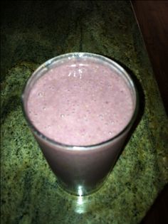 a smoothie in a glass sitting on a counter