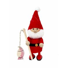 a red and white stuffed santa holding a wooden stick next to an egg ornament