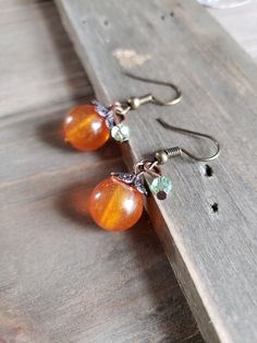 Fun and festive handmade resin pumpkin earrings with green crystal cut glass on rustic bronze metals. Delicate and detailed amber pumpkins with warm bronze stems and leaves. Cute addition to any outfit. Beautiful and sweet gift for a friend or loved one. Be sure to check out the HOLIDAY EARRINGS section at EarringsbyLCreations for all beautiful seasonal pieces available! https://www.etsy.com/shop/EarringsByLCreations?section_id=25034194 Made with quality materials and always nickel and lead free Resin Pumpkin, Fall Bead, Holiday Earrings, Wrapped Earrings, Pumpkin Earrings, Fall Earrings, Mini Pumpkins, Holiday Earring, Wire Wrapped Earrings