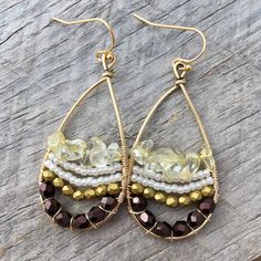 These fun earrings are made with a gold plated drop frame, tarnish-resistant gold plated copper wire, eggplant and gold faceted Czech glass beads, white Japanese seed beads, and citrine chip beads. The ear hooks are 14k gold-plated. These earrings measure 24x47mm and are lightweight. Colors do vary on different monitors; please keep this in mind. ~Care instructions: Not waterproof- do not wear while showering, swimming, etc. As with all jewelry, keep away from children and pets, and store in a d Handmade Czech Glass Drop Earrings, Bohemian Gold Beaded Crystal Earrings, Bohemian Teardrop Wire Wrapped Earrings, Bohemian Teardrop Wire Wrapped Jewelry, Bohemian Wire Wrapped Teardrop Jewelry, Bohemian Hoop Earrings With Faceted Beads, Bohemian 14k Gold-filled Earrings, Bohemian Gold Earrings With Faceted Beads, Gold 14k Bohemian Earrings