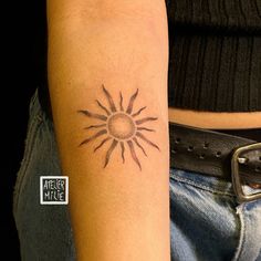 a woman's arm with a tattoo on it that has a sun in the middle