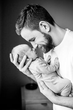 a man holding a baby in his arms