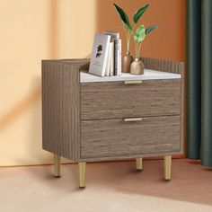 a nightstand with two books and a plant on it in front of a curtained window