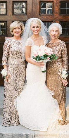 three women standing next to each other in front of a wooden door wearing gold dresses